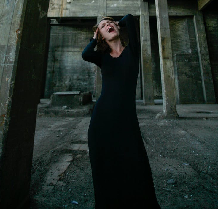 woman in black long sleeve dress screaming